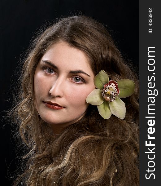 Face of a young woman with orchid at hair. Face of a young woman with orchid at hair
