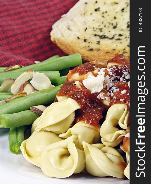 Tortellini with sauce and green beans and bread. Tortellini with sauce and green beans and bread.
