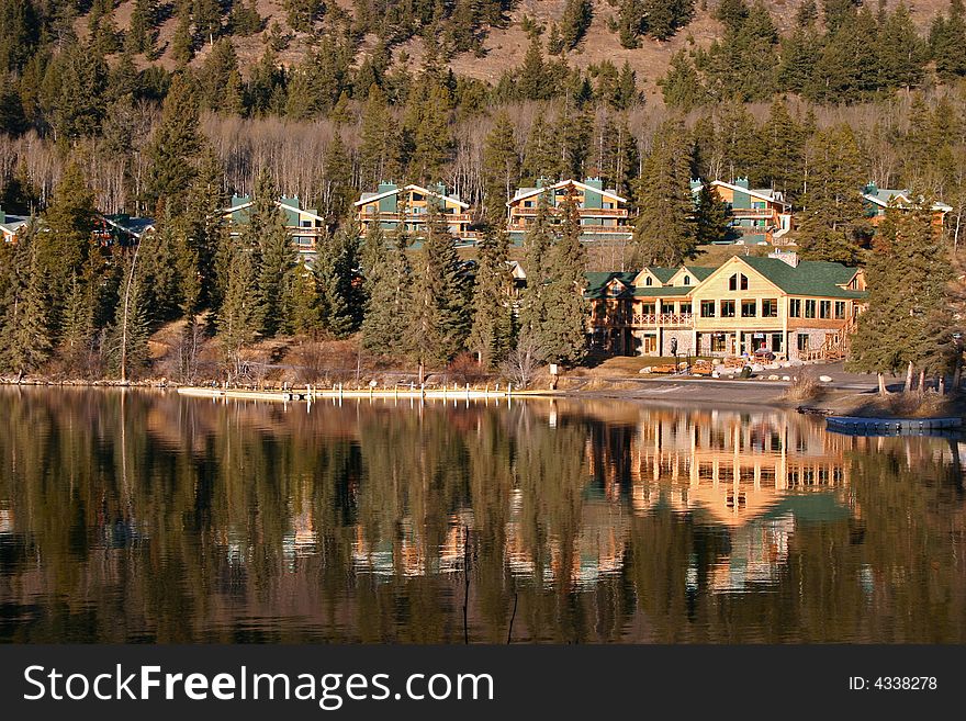 A modern mountain resort reflecting off of a calm lake. A modern mountain resort reflecting off of a calm lake