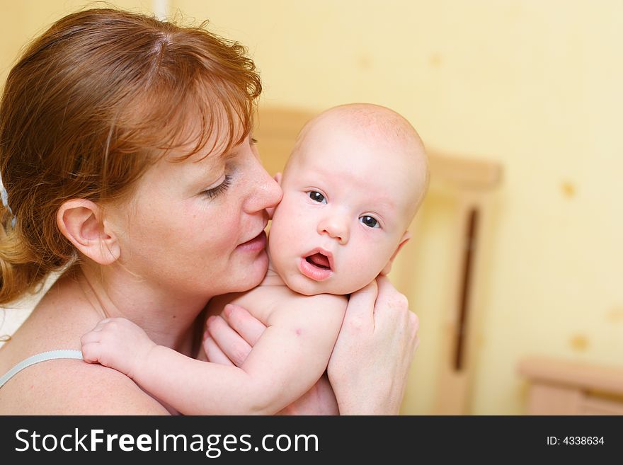 Mother gently holding baby in hands. Baby surprised.