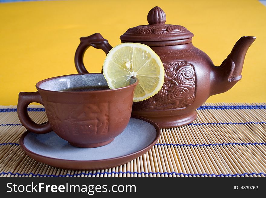 Chinese tea service with a full cup of tea and lemon