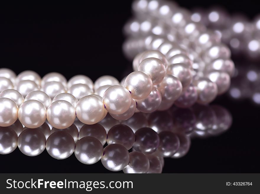 Necklace from pearls on a black background
