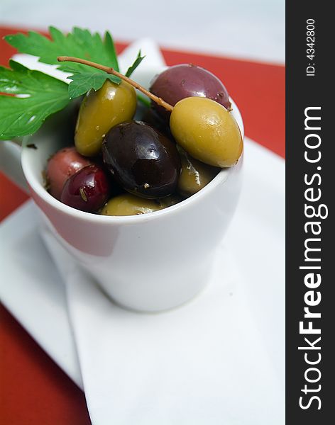 Mixed olives in bowl on red tablecloth