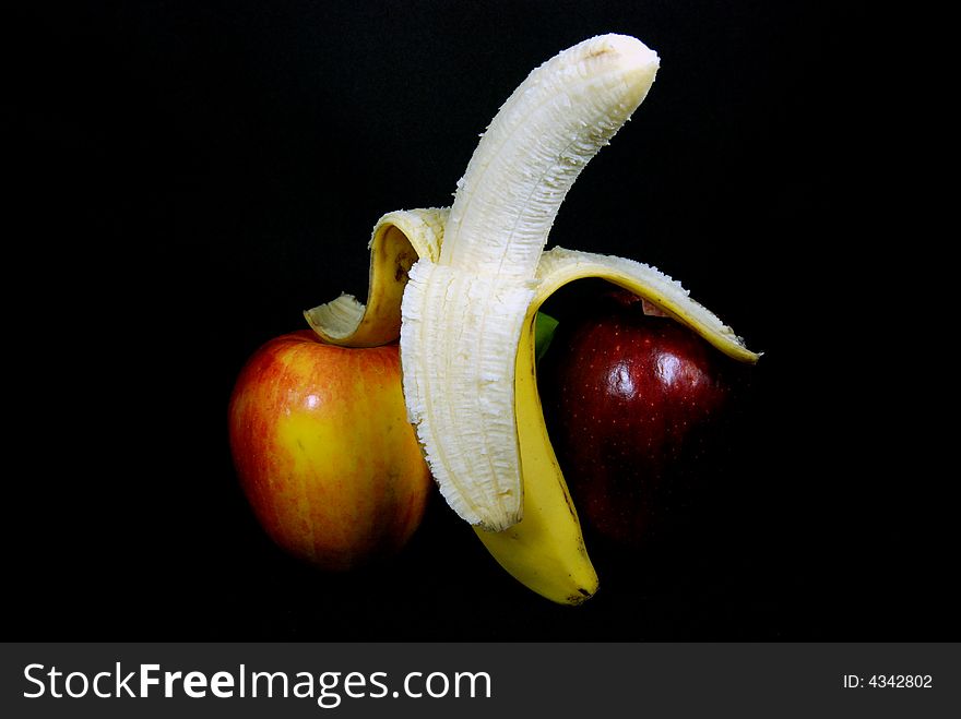 Peeled banana leaning on an apple. Peeled banana leaning on an apple.