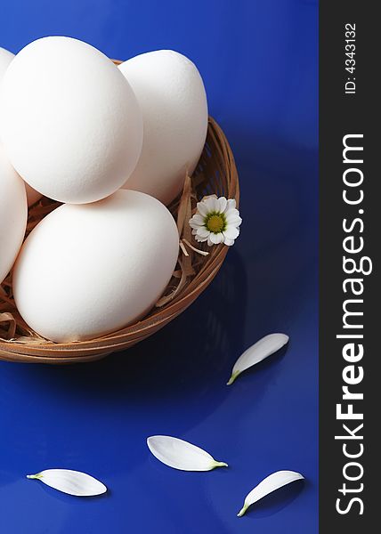 White eggs with flower on blue background. White eggs with flower on blue background.