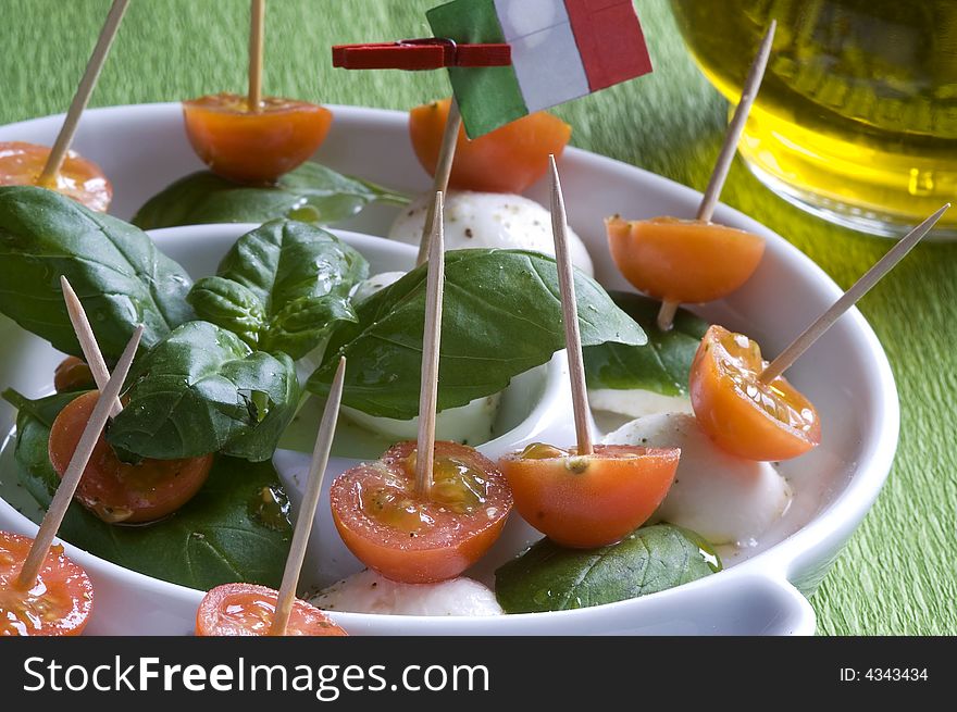 Arrangement of mozzarella and tomatoes with basil and olive oil. Arrangement of mozzarella and tomatoes with basil and olive oil.