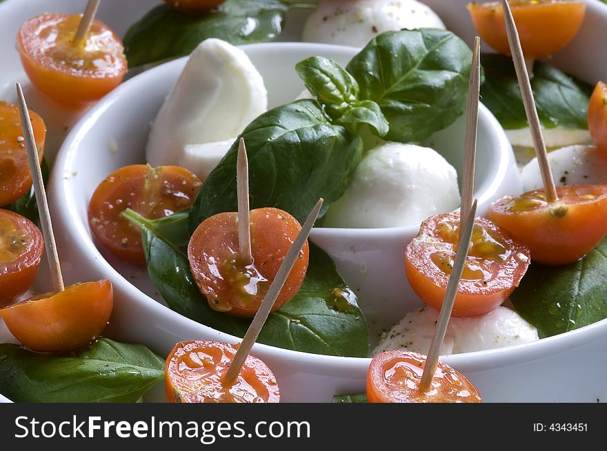 Arrangement of mozzarella and tomatoes with basil and olive oil. Arrangement of mozzarella and tomatoes with basil and olive oil.