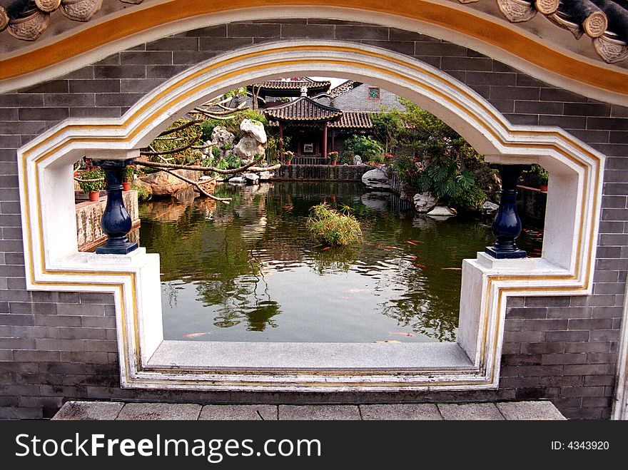 A fan-shaped window on the grey-bricked wall in a Chinese traditional ancient garden,Qinghui Garden,Shunde,Guangdong,China,Asia. A fan-shaped window on the grey-bricked wall in a Chinese traditional ancient garden,Qinghui Garden,Shunde,Guangdong,China,Asia.
