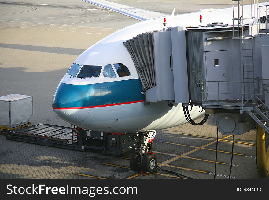 An airplane uploading passengers in the airport. An airplane uploading passengers in the airport