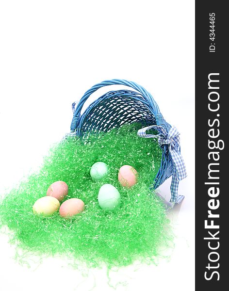 Pastel colored easter eggs and green grass spilling out of a country blue colored easter basket. Pastel colored easter eggs and green grass spilling out of a country blue colored easter basket.