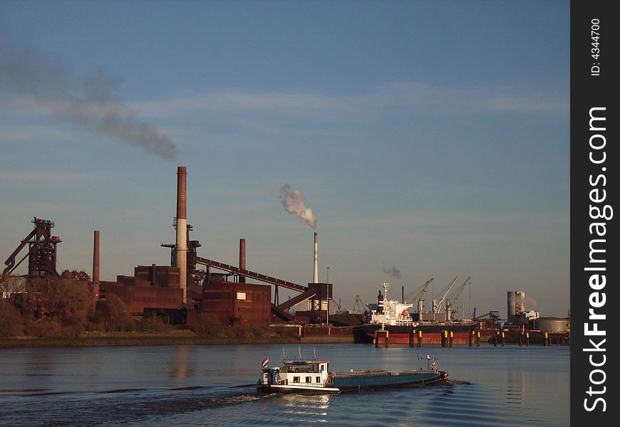 Self-propelled barge in front of a large industrial plant. Self-propelled barge in front of a large industrial plant