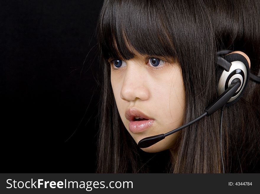 Young teenager communicates with a Headset befor a black background. Young teenager communicates with a Headset befor a black background