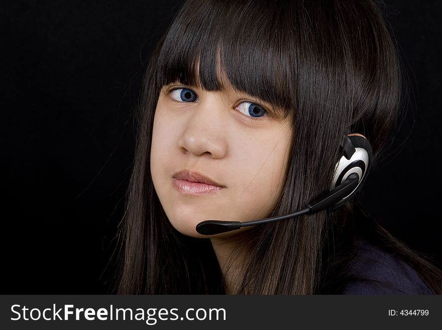 Young teenager communicates with a Headset befor a black background. Young teenager communicates with a Headset befor a black background