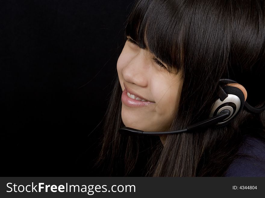 Young teenager communicates with a Headset befor a black background. Young teenager communicates with a Headset befor a black background