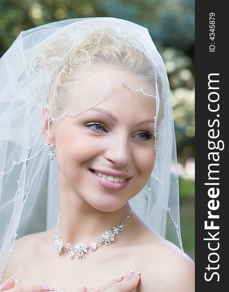 Beautiful blond blue-eyes bride laughs in the meadow. Beautiful blond blue-eyes bride laughs in the meadow