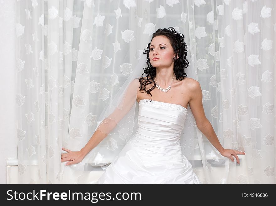 Bride stands by the window. Bride stands by the window