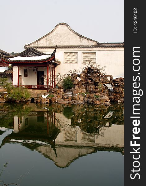 A pavilion with it's beautiful surroundings and their reflection in the water.This picture is taken in Net lion park in Suzhou ,China.