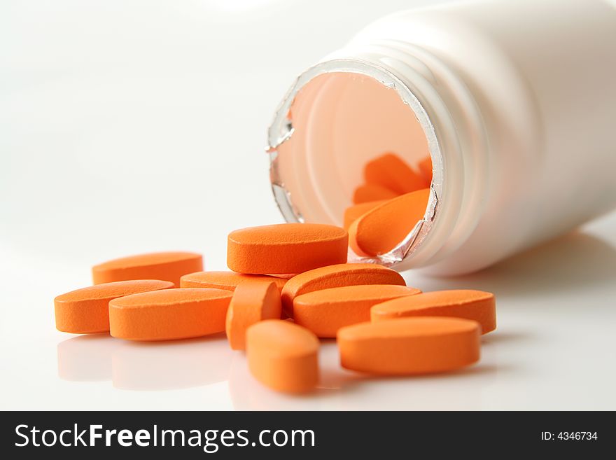 Orange medicine pills on a light background