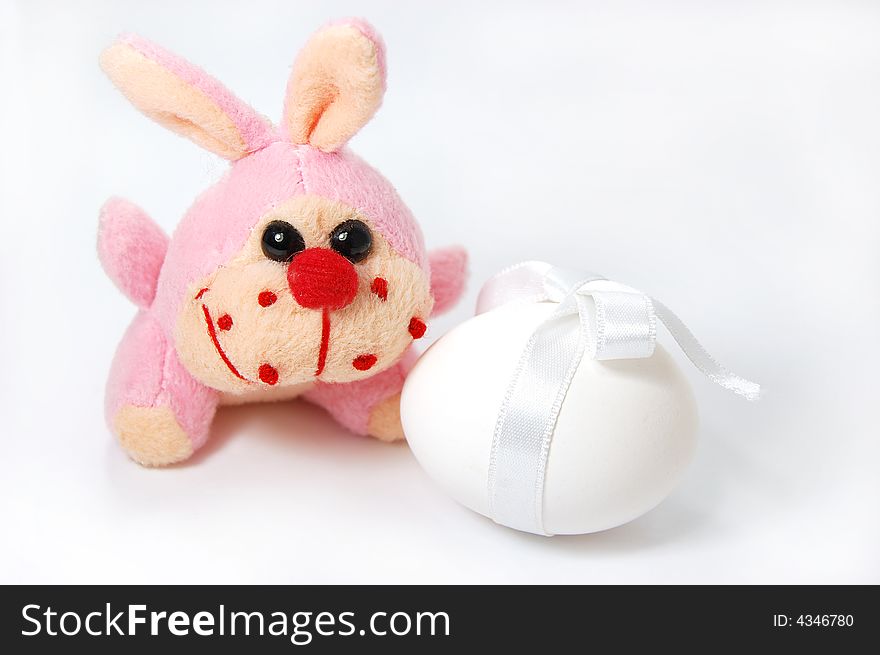 Toy bunny and white egg isolated on white. Toy bunny and white egg isolated on white