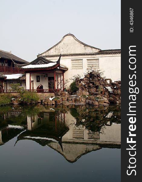 A pavilion with it's beautiful surroundings and their reflection in the water.This picture is taken in Net lion park in Suzhou ,China.