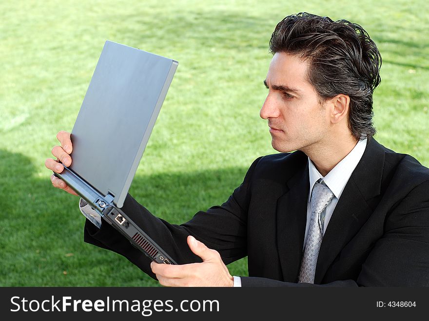 Confident and successful young adult businessman working on his laptop computer