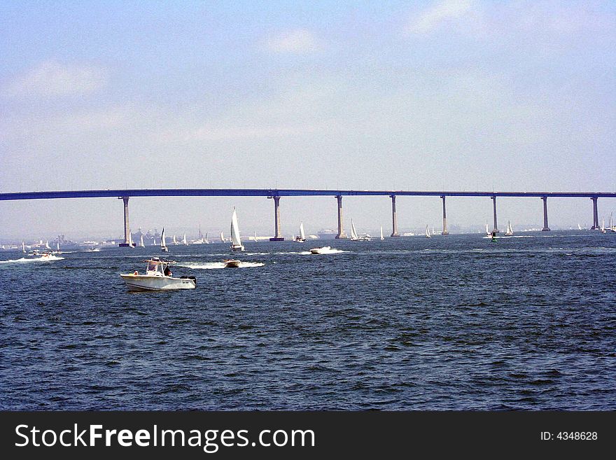 Image of a bridge in back of boats in the ocean. Image of a bridge in back of boats in the ocean