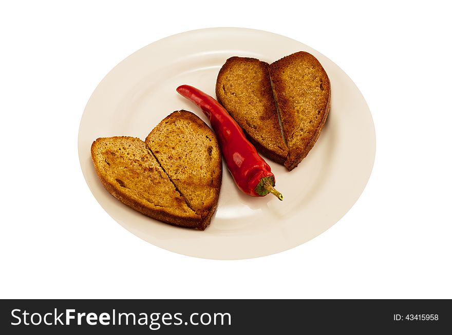 Hot red pepper on a white plate with two heart-shaped toast. Hot red pepper on a white plate with two heart-shaped toast