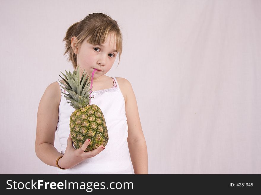 Young girl drinking from a pineapple. Young girl drinking from a pineapple