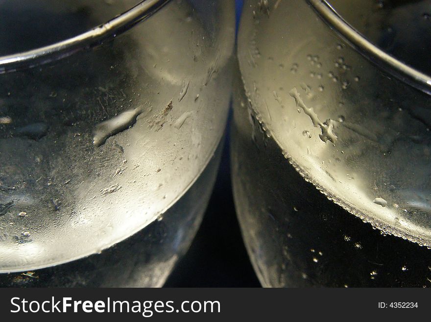 Close-up of two champagne glasses filled with bubbly on a blue background. Close-up of two champagne glasses filled with bubbly on a blue background