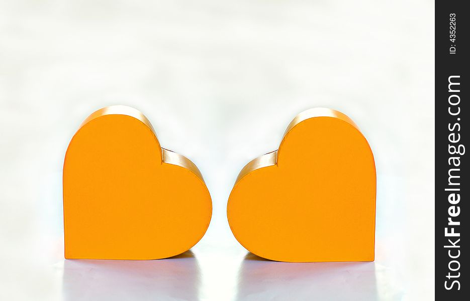 Two yellow hearts over white background