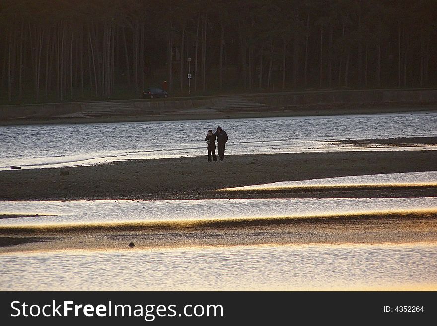 Lovers walking by the sea, during low tide; suitable for conceptual love and Valentine cards