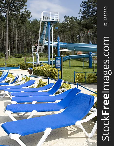 Several blue chairs around a swiming pool. Several blue chairs around a swiming pool