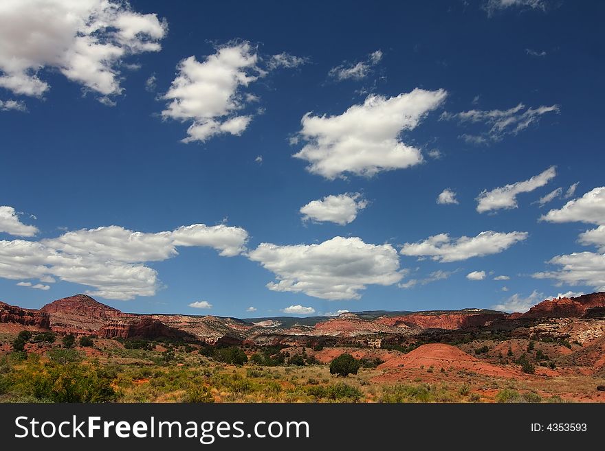 View of the red rock formations in Capitol Reef National Park with blue skyï¿½s and clouds. View of the red rock formations in Capitol Reef National Park with blue skyï¿½s and clouds