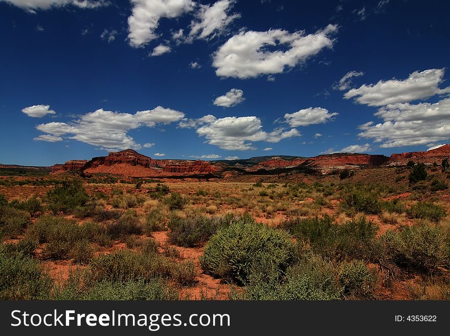 View of the red rock formations in Capitol Reef National Park with blue skyï¿½s and clouds. View of the red rock formations in Capitol Reef National Park with blue skyï¿½s and clouds