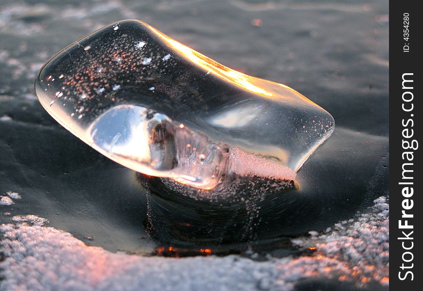 Translucent ice bit collects and reflects sunset light. Translucent ice bit collects and reflects sunset light