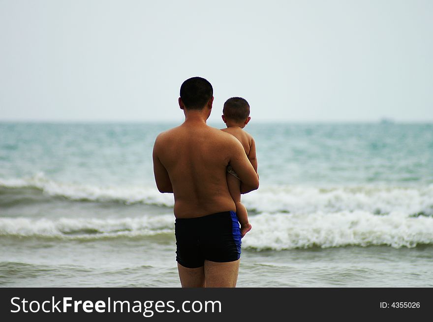 Father hold his baby boy standing on the beach. Father hold his baby boy standing on the beach