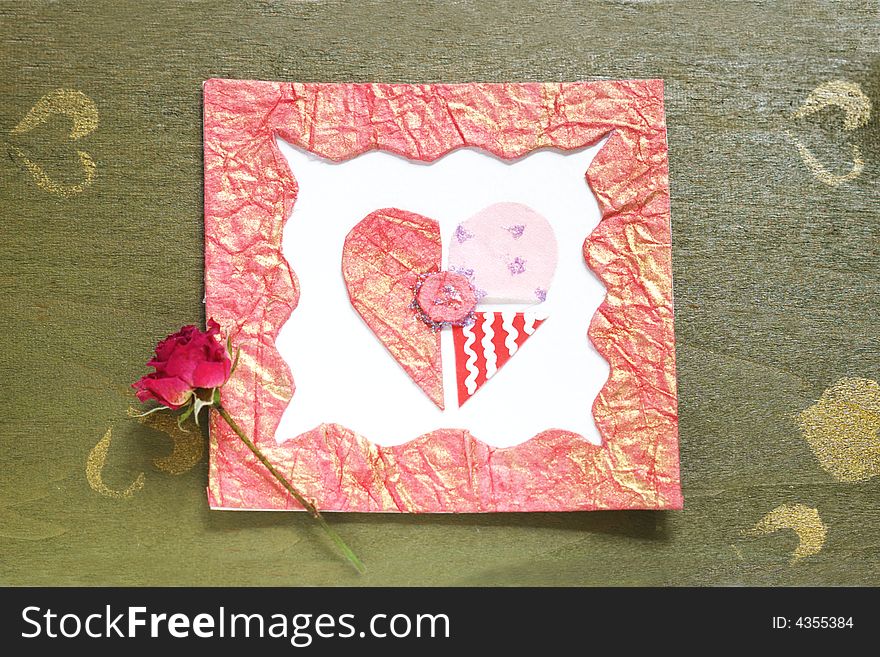 A dried rose placed on top of an old  green wood table. A dried rose placed on top of an old  green wood table