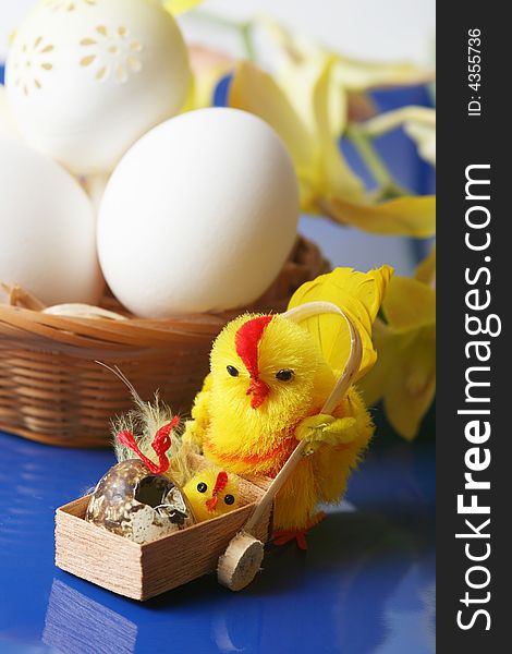 Easter motive.Hen and her chick,white eggs on blue background.
