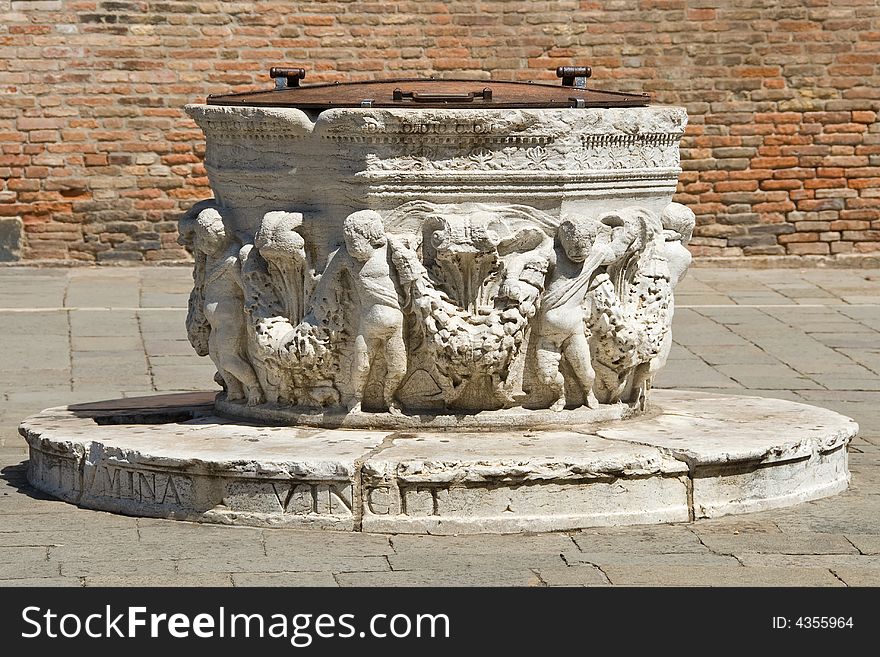 Old water well in a middle of a paza in Venice. Currently not in use (replaced by a modern plumbing system). Old water well in a middle of a paza in Venice. Currently not in use (replaced by a modern plumbing system)