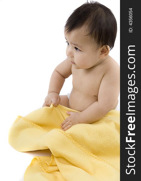 Charming baby with yellow soft cover before white background