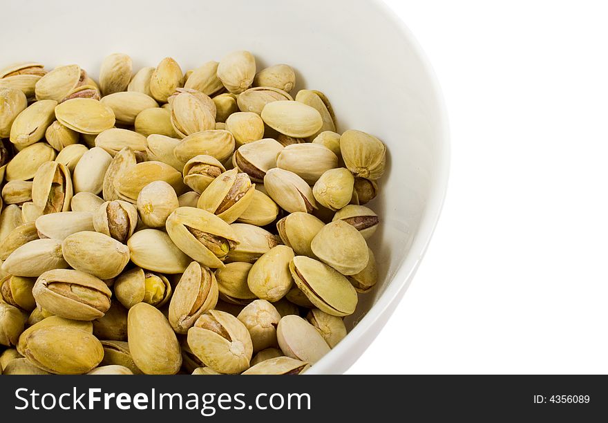 Bowl of pistachios close-up over white