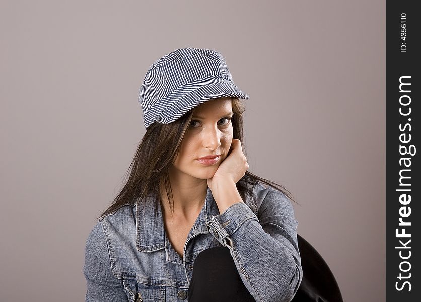 A brunette model in denim jacket and cap. A brunette model in denim jacket and cap