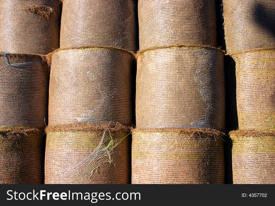 A stack of harvested straw bales in a farmers field photographed in close crop. A stack of harvested straw bales in a farmers field photographed in close crop