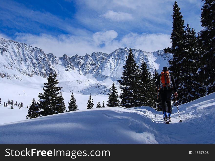 Skier skinning along trail to the peaks at the back of mayflower gulch