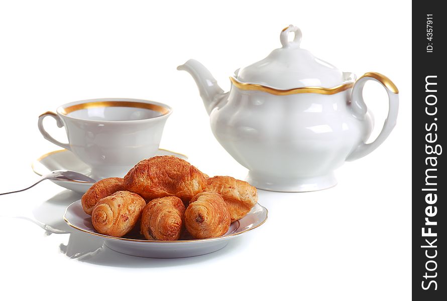 Cup of tea and croissants on white