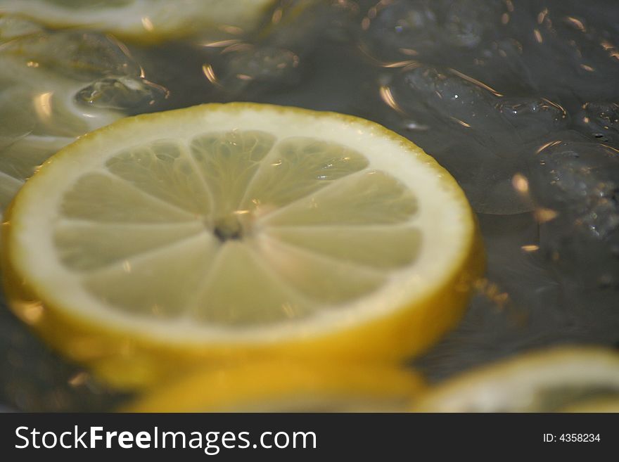 Lemon slices floating on ice cold water.