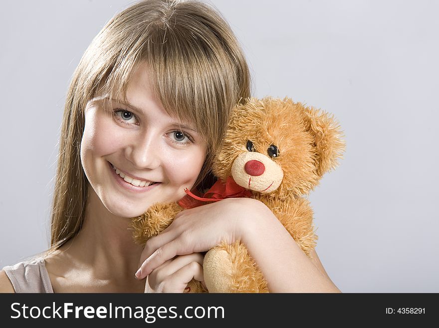 Smiling teen holding a teddy bear toy