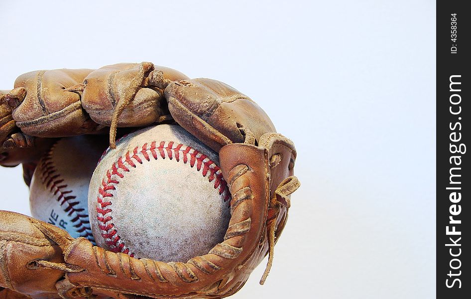 A worn baseball mitt and ball isolated on white. A worn baseball mitt and ball isolated on white