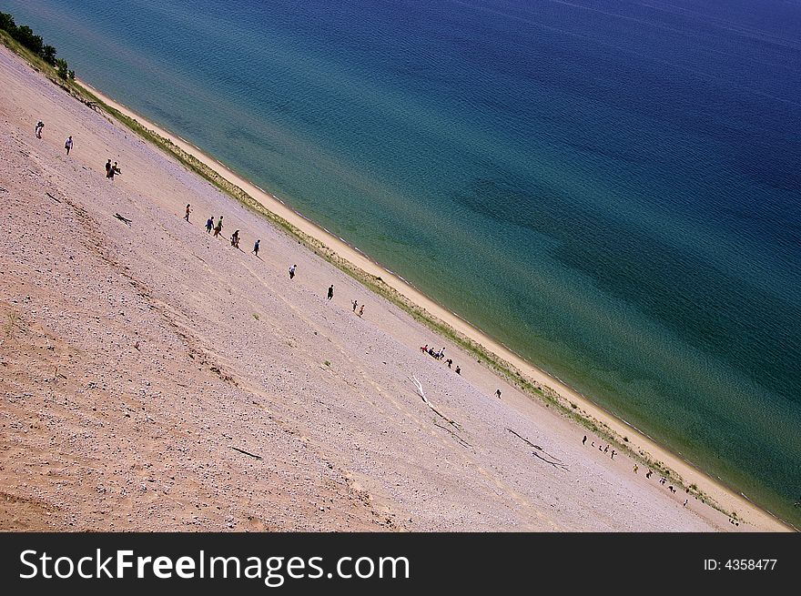 A steep dune by the colorful water