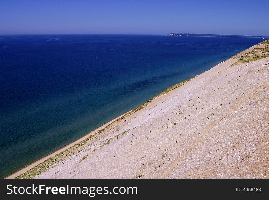 A steep dune and the colorful water of Lake Michigan. A steep dune and the colorful water of Lake Michigan